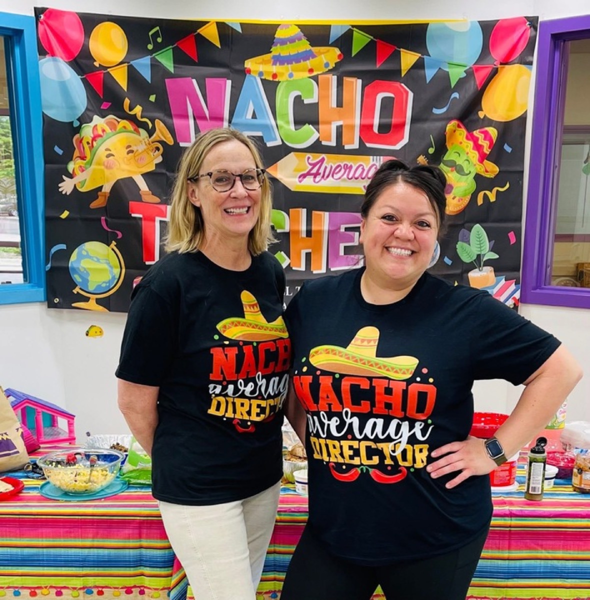 Two directors in Nacho Average Director shirts in front of the celebration backdrop